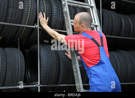 Ein motivierter Arbeiter in einer Reifen Werkstatt Auffüllen der Ware. Stockfoto