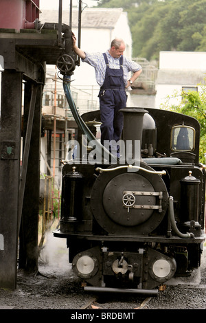 Zug Ingenieur Nachfüllen von Wasser für Dampfmaschinen im Ffestiniog Bahn. Porthmadog Gwynedd North Wales Großbritannien Stockfoto