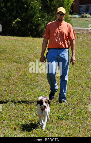 Hundetrainer Spaziergang durch Feld mit Brittany in Harrison County, Indiana Stockfoto