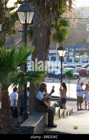 Ein Straßenmusikant Gitarre spielen und singen für Touristen in der alten Stadt von Puerto Del Carmen, Lanzarote, Kanarische Inseln Stockfoto