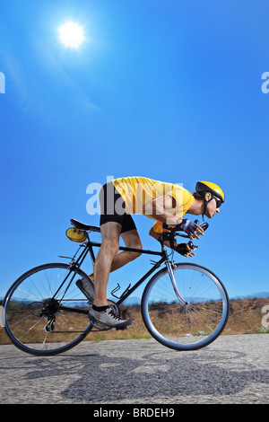 Ein Biker mit dem Fahrrad auf einer Landstraße Stockfoto