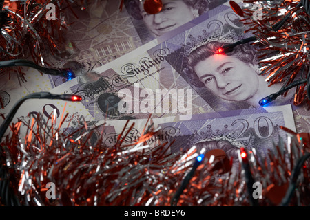 Haufen von zwanzig Pfund Sterling Banknoten mit Lametta Weihnachtsdekoration und Lichter Stockfoto