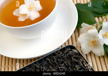 Eine Tasse Tee auf einem Tablett mit getrockneten Tee und Jasmin branch Stockfoto