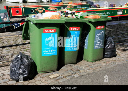 Überquellenden grüne recycling-Behälter und Mülltüten gesammelt werden warten Stockfoto