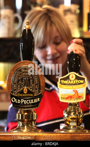 Bardame ziehen ein Pint Theakston Bier in der Brauerei in Masham, North Yorkshire Stockfoto