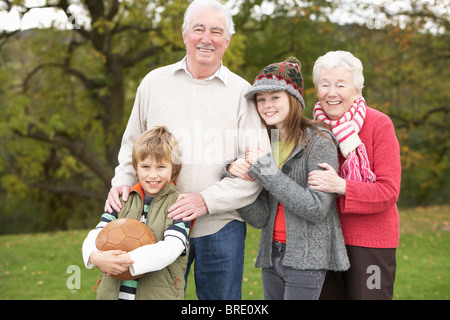 Großeltern mit Enkeln halten Fußball außerhalb Stockfoto