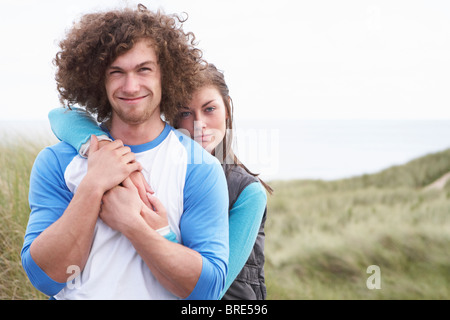 Junge Paare, die durch die Sanddünen, die warme Kleidung zu tragen Stockfoto