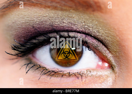 Braune Augen einer Frau mit dem Zeichen für Biohazard, symbolisches Bild für Genertic engineering Stockfoto
