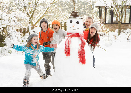 Familie Gebäude Schneemann im Garten Stockfoto