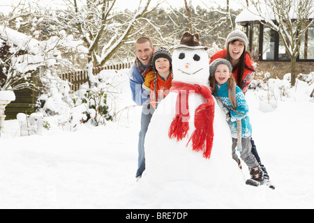 Familie Gebäude Schneemann im Garten Stockfoto