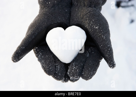 Nahaufnahme von Händen mit Herz aus Schnee Stockfoto