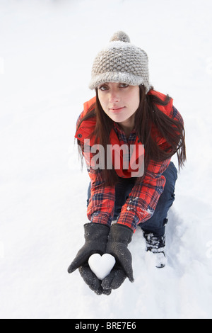 Frau mit Herz aus Schnee Stockfoto