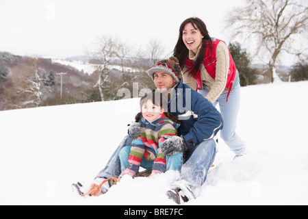 Familie im Schnee reiten auf Schlitten Stockfoto