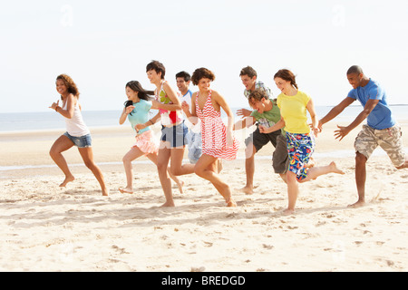 Gruppe von Freunden zusammen Strand entlang laufen Stockfoto