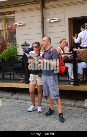 Touristen-paar auf der Suche auf Karte und Reiseführer Stortorget Platz Gamla Stan Altstadt Stockholm Schweden Europa Stockfoto