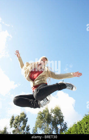 Junge Frau am Trampolin springen In der Luft gefangen Stockfoto