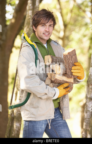 Mann im Freien im Herbst Wald sammeln Protokolle Stockfoto