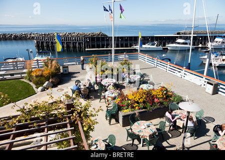 Menschen, die genießen, Essen im Freien auf der Terrasse im Waterfront Café mit herrlicher Blick mit Blick auf Marina & Puget Sound Edmonds WA Stockfoto