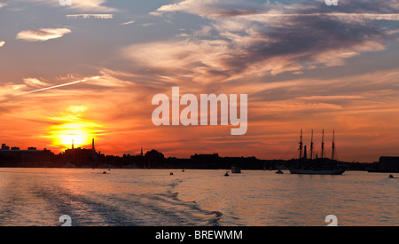 Boston Harbor Sonnenuntergang. Die Sonne geht über Boston und ihre berühmten Leonard P. Zakim Bunker Hill Memorial Bridge. Stockfoto