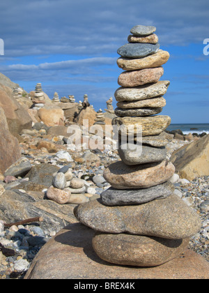 Rock Cairn bei Sonnenuntergang am felsigen Strand Stockfoto