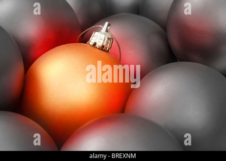 Goldene Weihnachtskugel unter viele graue Ornamente Stockfoto