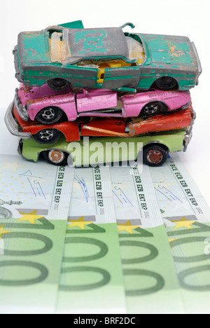 Miniatur-Autos auf Banknoten, symbolisches Bild für Abwrackprämie gebrochen Stockfoto