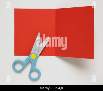Blatt rote Karte mit Bügelfalte gefaltet entlang Zentrum, blaue behandelt Schere Stockfoto