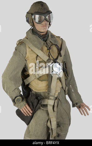 Luftwaffe, Pilote de chasse de la Luftwaffe, sur Mannequin, comprenant un bonnet de vol d'été (Traces d'usure) complet avec ses écouteurs et laryngophones, fil électrique avec pry, trois crochets de fixation pour le masque à oxygène. Une combinaison d'été en textile brun. modèle précoce à deux fermeures éclair en cuir brun (Traces de restauration et d'usure), un gilet de sauvetage (modèle Marine), un parachine complete avec ses lanières et sa voilure, une boussole de bras, une paire de lunettes de Protection, control, Stockfoto