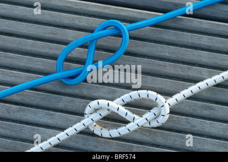 Zwei Achter Knoten, eine blaue, eine weiße, auf decking Stockfoto