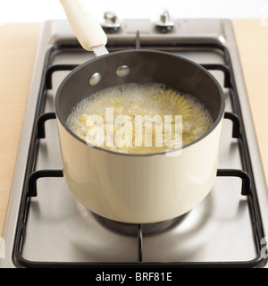 Schüssel mit Fusilli Nudeln kochen in Pfanne, Nahaufnahme Stockfoto