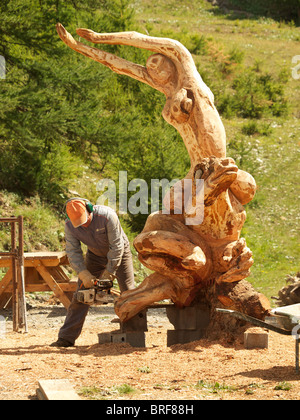 Künstler Bildhauer schaffen eine hölzerne Skulptur mit einer Kettensäge in Les Orres, Hautes Alpes, Frankreich Stockfoto