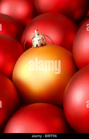 Nahaufnahme von gold Weihnachtsdekoration, umgeben von roten Kugeln Stockfoto