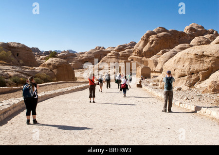 Touristen zu Fuß in Richtung des Siq, Canyon Eingang zum alten Felsen geschnitzt Stadt Petra, Jordanien. Stockfoto