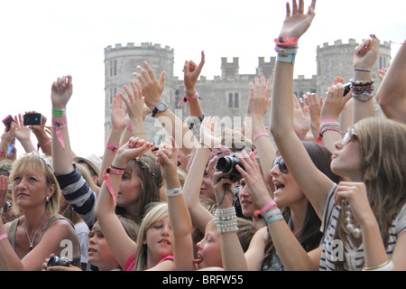 Eine Schar Kinder im Camp Bestival, freundliche Familienfest, toben auf der Hauptbühne. Lulworth Castle befindet sich hinter. Stockfoto