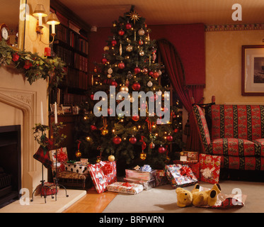 Verpackte Geschenke unter hoch dekorierten Weihnachtsbaum in Ecke des traditionellen Wohnzimmer Stockfoto