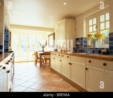 Terrakotta geflieste Boden im Wintergarten Wohnzimmer mit Korbstuhl