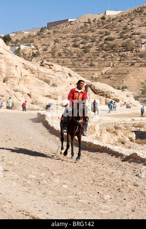 Touristen auf Reiten an den Siq, Canyon Eingang zum alten Felsen geschnitzt Stadt Petra, Jordanien. Stockfoto