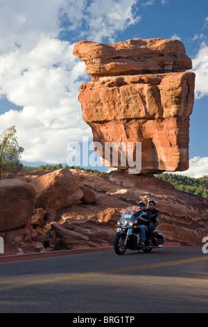 Paar auf einem Motorrad zu fahren, vorbei an Balanced Rock, Garten der Götter, National Natural Landmark, Colorado Springs, Colorado, USA Stockfoto