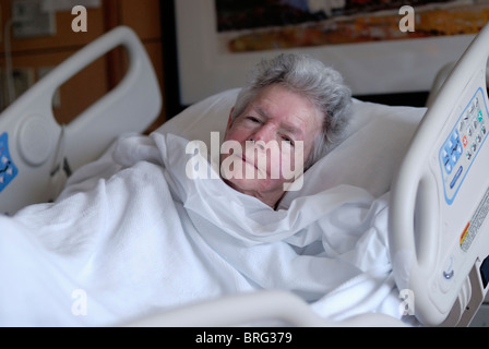 80 Jahre alte Frau, die in einem Krankenhausbett liegt Stockfoto