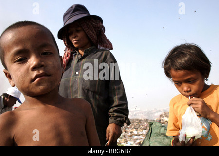 Ein kleiner Junge, der ein Kinderarbeiter nimmt eine kurze Pause bei Stung Meanchey Mülldeponie in Phnom Penh Kambodscha. Stockfoto