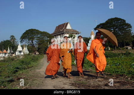 Vier buddhistische Mönche, die ihren Wohnsitz im Wat Bangkok (Hintergrund) sind für Schulklassen in Kampong Cham, Kambodscha Fuß. Stockfoto