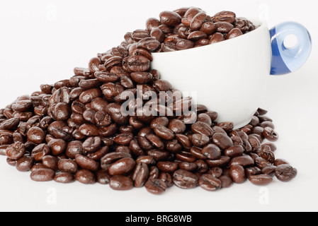 Überlaufen von einer Kaffeetasse Bohnen Stockfoto