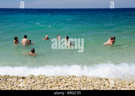 Gruppe von Menschen schwimmen in einem Meer genießen in kleinen Wellen während der hellen Sonnentag, Insel Silba, Kroatien Stockfoto