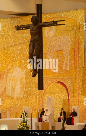 Papst Benedikt XVI. sitzt unterhalb ein Kreuz in der Basilika der Heiligen Dreifaltigkeit im Heiligtum Unserer Lieben Frau von Fatima in Portugal, Mai 2010 Stockfoto
