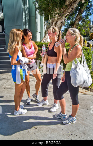 Gekleidet über eine Trainingseinheit, vier sportliche Frau treffen außerhalb eines Gymnasiums in Laguna Niguel, CA. Hinweis Hispanic im Zentrum. Stockfoto