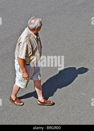 Reifen / im mittleren Alter Mann zu Fuß über Straße - Frankreich. Stockfoto