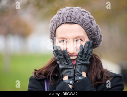 glücklich Reife Frau mit Winterkleidung und Kopf in Händen Stockfoto