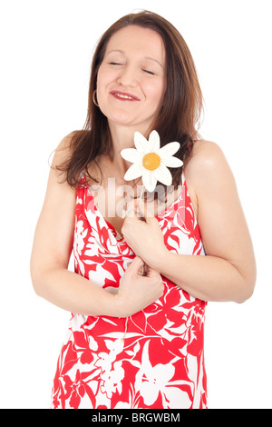 niedliche Reife Frau umarmt künstlichen Gänseblümchen und Augen schließen Stockfoto