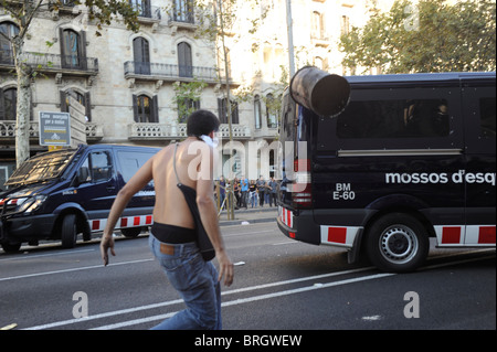 Ein Aktivist anti-System wirft ein Papierkorb gegen einen Polizeiwagen bei in der Innenstadt von Barcelona während des Streiks Auseinandersetzungen. Stockfoto