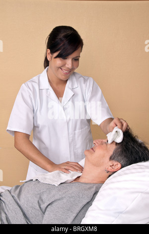 Eine Krankenschwester wäscht ein patient Stockfoto